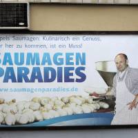 An advertising poster reading \'pig stomach paradise\' (Saumagenparadies) is pictured in the village of Kallstadt, southern Germany, on June 8. Kallstadt owes its reputation to crisp white wines, stunning hiking trails and the local delicacy of pig\'s stomach (Saumagen). The village is also home of ancestors of the presumptive designated presidential U.S. candidate of the Republican Party Donald Trump. | AFP-JIJI