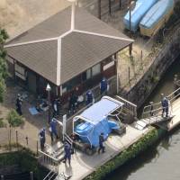 Investigators search the pond where body parts were found in Himonya Park, Tokyo\'s Meguro Ward, on Thursday. | KYODO