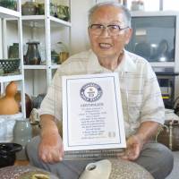 Shigemi Hirata, a 96-year-old man from western Japan, poses for a photo at his home on Friday with a Guinness World Records certificate recognizing him as the world\'s oldest graduate. | KYODO