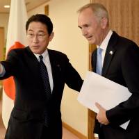 Foreign Minister Fumio Kishida (left) welcomes British Ambassador to Japan Tim Hitchens prior to their talks at the Foreign Ministry on Monday. | AFP-JIJI