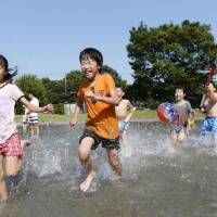 Children play in a park in Tatebayashi, Gunma Prefecture, on Saturday as the temperature rises to 35 degrees. | KYODO