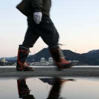A man walks past the Takahama nuclear power plant in Fukui Prefecture. Nuclear power safety is one of the main issues on the minds of Kansai voters for the Upper House election next month. Atomic safety, shinkansen issues complicate Upper House equation for Kansai voters
