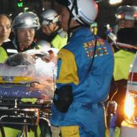 Police carry a person rescued from a landslide that occurred Tuesday evening in Nagasaki. | KYODO