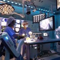Staff members simulate brain surgery using chicken meat during a \'smart surgery\' demonstration at the Smart Cyber Operating Theater intensive care unit at Tokyo Women\'s Medical University in Tokyo on Thursday. | SHUSUKE MURAI