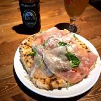 Beer and pizza: Topped with prosciutto, arugula, Parmesan cheese and white truffle oil, Hazama’s best-seller is a good match for the craft brews in M’unica’s well-stocked fridge. | ROBBIE SWINNERTON