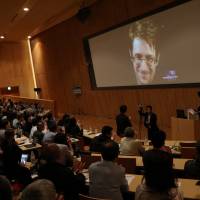 From Russia with caution: NSA whistleblower Edward Snowden appears via video link at a symposium on surveillance and civil rights in Tokyo on June 4. Who's watching whom in Japan? It's a state secret
