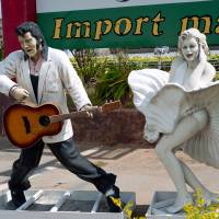 Figures of Elvis and Marilyn Monroe frozen outside an Import Mart along the main road. | STEPHEN MANSFIELD