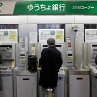 Money problems: People use automatic teller machines at a Japan Post Bank Co. branch in Tokyo. Thieves last month stole more than ¥2 billion from ATMs using hacked cash cards during a three-hour period, raising doubts about Japan’s ability to monitor and prevent cybercrime. Japan sleeps while cybercriminals get smarter