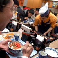 Welcome to the cheap meats: Customers chow down on beef bowls during a one-day revival of the popular dish at a Yoshinoya branch in 2005. Gyūdon was off the menu for years from 2004 during the BSE scare. | BLOOMBERG