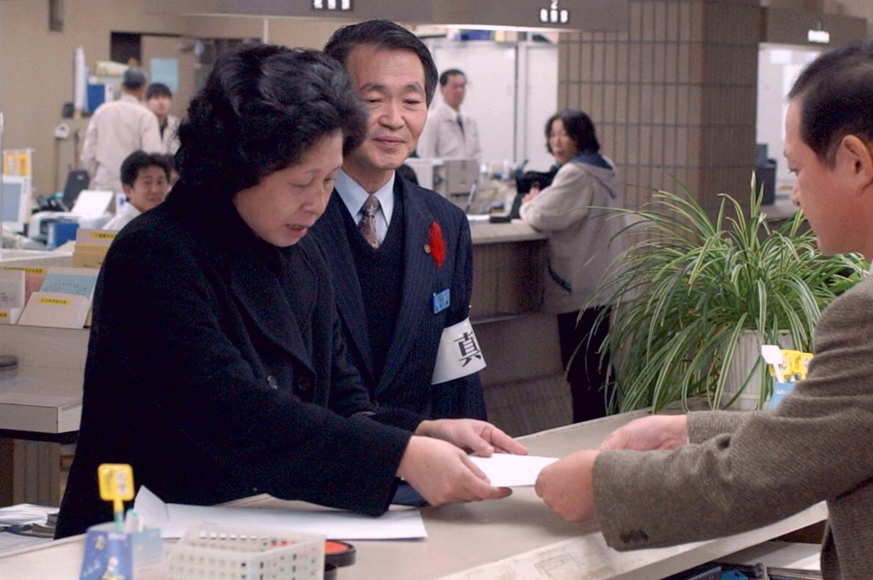 Japanese again: Hitomi Soga, who was abducted to North Korea in 1978, hands papers to an official at Mano town office on the island of Sadogashima, Niigata Prefecture, in 2002, to have her information reentered in her family's koseki family register. Soga had been removed from the family register as a missing person 16 years earlier. | KYODO