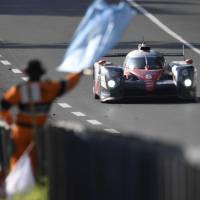 Kamui Kobayashi drives his Toyota past a marshal during the Le Mans 24 Hours on Saturday. | AFP-JIJI