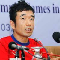 Japanese-Cambodian comedian Hiroshi Neko, who\'ll represent Cambodia in the men\'s marathon at the 2016 Rio de Janeiro Olympics, speaks at a news conference on Friday in Phnom Penh. | KYODO