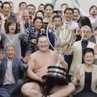 Yokozuna Hakuho poses with the Emperor’s Cup after the Summer Basho at Ryogoku Kokugikan on May 22. | KYODO