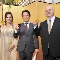 Jordan Ambassador Demiye Haddad (right), and his wife, Shifa (left), share a toast with Parliamentary Vice-Minister for Foreign Affairs Masakazu Hamachi during a reception to celebrate the 70th Anniversary of the country\'s Independence Day and The Centennial of the Great Arab Revolt, at the Hotel Okura Tokyo on May 25. | YOSHIAKI MIURA