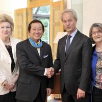 Swedish Ambassador Magnus Robach (second from right) shakes hands with Honorary Consul in Nagano Soichiro Yoshida, after presenting him with the insignia of Commander of Order of the Polar Star for his long service, flanked by Yoshida\'s wife, Carole (left) and the ambassador\'s wife, Michele, at the embassy in Tokyo on June 3. | YOSHIAKI MIURA