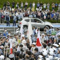 Anti-Korean protesters clash with activists opposed to hate speech as police try to separate the two groups on Sunday at a park in Kawasaki. | KYODO