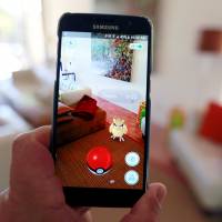 The augmented reality mobile game \'Pokemon Go\' is shown on a smartphone screen. Niantic Inc., which developed \'Pokemon Go\' with Nintendo Co. and The Pokemon Co., is working to boost server capacity to introduce the game outside of the U.S., Australia and New Zealand. | REUTERS