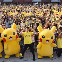 People dressed as Pikachu, a famous Pokemon character, dance with fans at the finale of the nine-day \"Pikachu Outbreak\" event in Yokohama last August. | AFP-JIJI