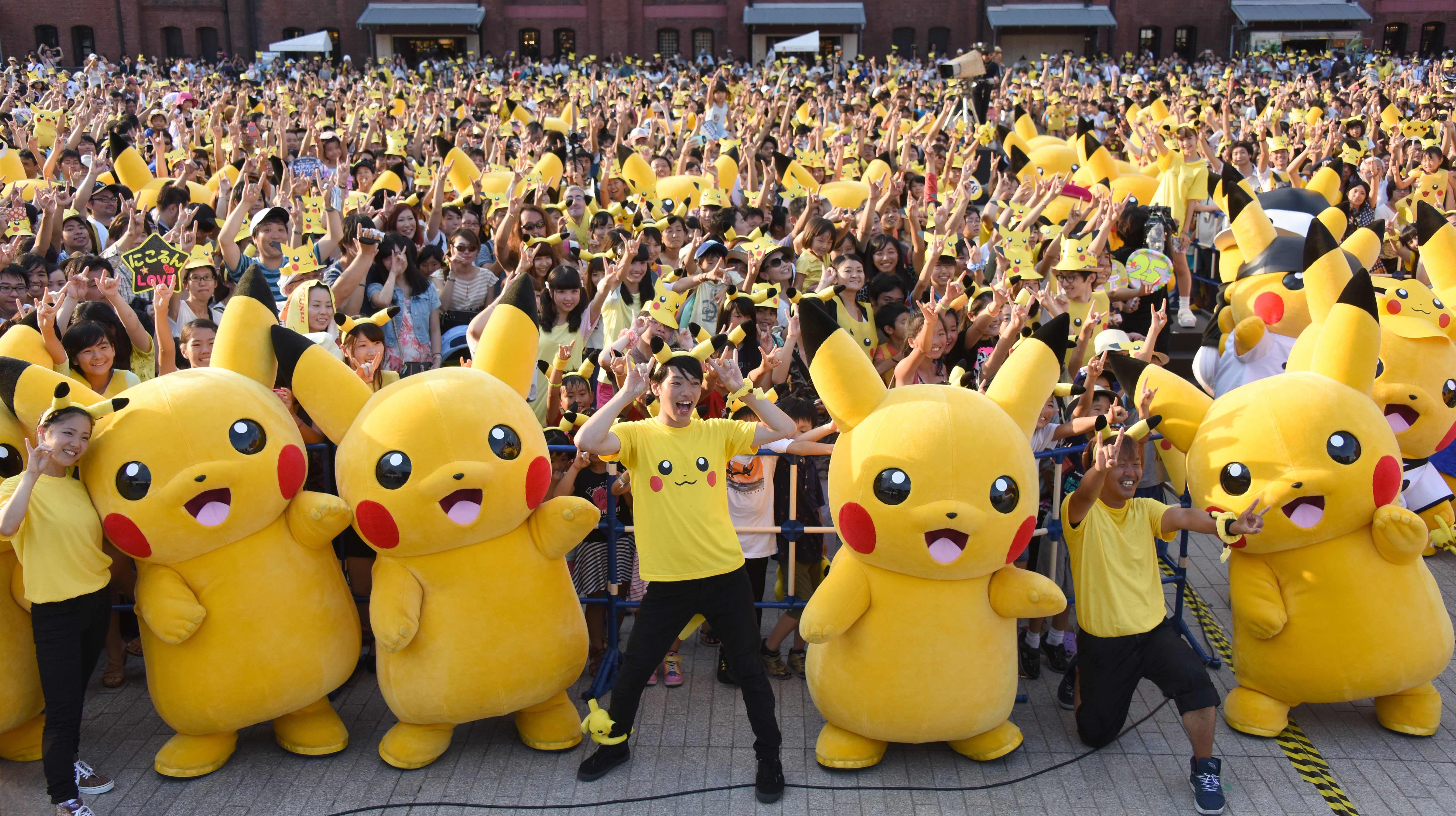 People dressed as Pikachu, a famous Pokemon character, dance with fans at the finale of the nine-day 'Pikachu Outbreak' event in Yokohama last August. | AFP-JIJI