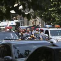 Armenian police and special forces secure the area around a police station in Yerevan Sunday,. Armenia security forces say a group of armed men has attacked the central police station, killing one officer, wounding two and taking others hostage. Armenia gunmen kill cop, take hostages at police station, demand release of opposition politicians