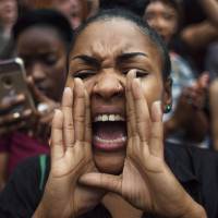 A protester shouts slogans during a march from Manhattan to Brooklyn in New York on Friday. Demonstrators took to the New York City streets chanted \"Hands up, don\'t shoot\" and \"No justice, no peace\" to protest the recent police shootings in Louisiana and Minnesota, one day after five police officers were killed by a sniper in Dallas. | AP