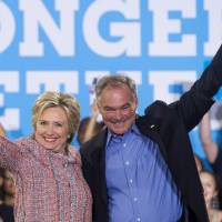 Democratic U.S. Presidential candidate Hillary Clinton and Virginia Sen. Tim Kaine wave during a campaign rally in Annandale, Virginia, on July 14. Clinton tapped Kaine to be her vice presidential pick Friday. | AFP-JIJI