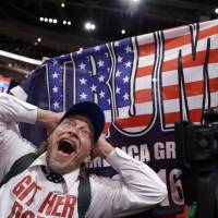 A California delegate reacts as a delegate from New York holds up a Donald Trump flag during the second day of the Republican National Convention in Cleveland on Tuesday. | AP