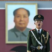 A policeman stands guard in Beijing\'s Tiananmen Square, near the portrait of late Chinese leader Mao Zedong, on July 13. | AFP-JIJI
