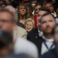 A delegate holds a placard with an image of Democratic presidential nominee Hillary Clinton as her husband, former President Bill Clinton, speaks Tuesday at the party\'s convention in Philadelphia. | REUTERS