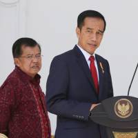 Indonesian President Joko \"Jokowi\" Widodo (center) and his deputy, Jusuf Kalla, walk to the podium before announcing new Cabinet ministers at Merdeka Palace in Jakarta on Wednesday. | AP