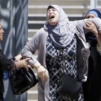 A woman still searching for her daughter reacts after learning of the death her grandson outside the Pasteur hospital in Nice on Saturday. | AP