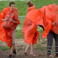 Pilgrims attending the World Youth Day event leave in the rain following a Mass celebrated by Pope Francis in the Campus Misericordiae in Brzegi, near Krakow, Poland, on Sunday. | AFP-JIJI