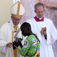 Pope Francis gives a symbolic flame to a representative of Africa during a holy Mass in the Campus Misericordiae in Brzegi, near Krakow, Poland, on Sunday. | AFP-JIJI