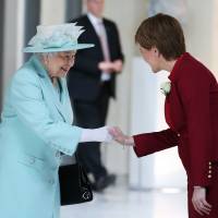 Queen Elizabeth II shakes hands with Scottish First Minister and Scottish National Party leader Nicola Sturgeon as she attends the opening of the fifth session of the Scottish Parliament in Edinburgh on Saturday. | AP