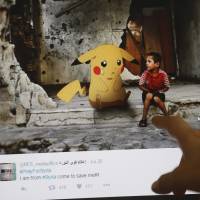 A journalist looks at a montage by Syrian artist Moustafa Jano using the international frenzy over the \"Pokemon Go\" game to draw new attention to the battle-scarred country. | AFP-JIJI