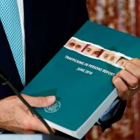 U.S. Secretary of State John Kerry holds a copy of the 2016 Trafficking in Persons report during the TIP Heroes Ceremony at the State Department in Washington on June 30. | REUTERS
