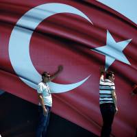Personnel prop up a stage backdrop before a pro-government demonstration in an Istanbul park on Tuesday. | REUTERS