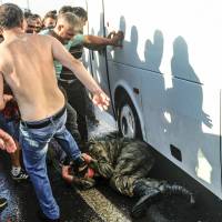 Turks Istanbul\'s Bosporus Bridge kick and beat a soldier who participated in the attempted coup on Saturday. | AP