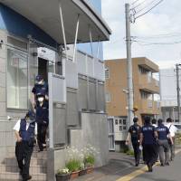 Public Security Intelligence Agency officers leave Aleph\'s new operating base in Sapporo after investigating the building on Thursday. | KYODO