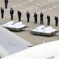 Government officials pray for the victims of Friday\'s Bangladesh terrorist attack after their bodies had arrived on a government plane at Tokyo\'s Haneda airport early Tuesday morning. | KYODO