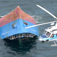The Yamato Maru No. 8 is overturned in the sea off Himeji, Hyogo Prefecture, on Friday after it collided with another cargo ship. | KYODO