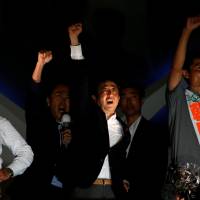 Prime Minister Shinzo Abe, leader of the ruling Liberal Democratic Party, raises his fist with candidates on Saturday, the last day of campaigning for Sunday\'s Upper House election, in Tokyo. | REUTERS