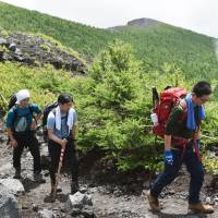 People begin climbing Mount Fuji on Sunday after three Shizuoka Prefecture trails opened for the season. | KYODO