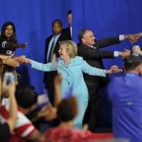 Democratic U.S. presidential candidate Hillary Clinton and her running mate, Sen. Tim Kaine, arrive for a campaign rally at Florida International University in Miami on Saturday. | AFP-JIJI
