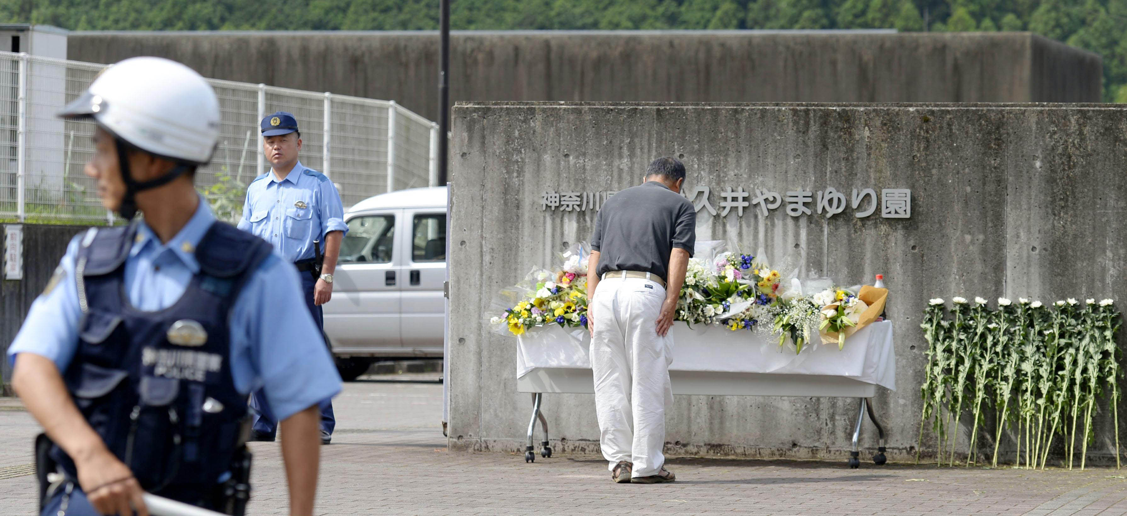 A man bows while paying his respects in front of the Tsukui Yamayuri En care facility in Kanagawa on Thursday where Tuesday's knife attack took place. | KYODO