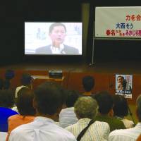 So Onishi, an independent running for a constituency covering Kochi and Tokushima prefectures, delivers a pre-recorded campaign speech by video in the city of Kochi on Sunday. Onishi does not plan to campaign in person in Kochi in the final few days before the Upper House election.  | REIJI YOSHIDA