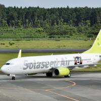 A Solaseed Air plane bearing the Kumamon bear character arrives at Kumamoto Airport on Tuesday. | KYODO