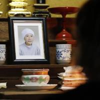 A photo of free diver Yushi Ikeda’s late mother, who was an ama free diver, sits in Ikeda’s home in Shima, Mie Prefecture, on June 19. He talks to it every day before he goes to work. | KYODO