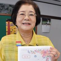 Naha Mayor Mikiko Shiroma shows a certificate for same-sex couples at the municipal government building Wednesday. | KYODO
