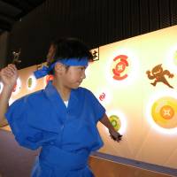 A child holds a throwing star during a preview of a ninja exhibition that kicks off Saturday at Miraikan. | KAZUAKI NAGATA